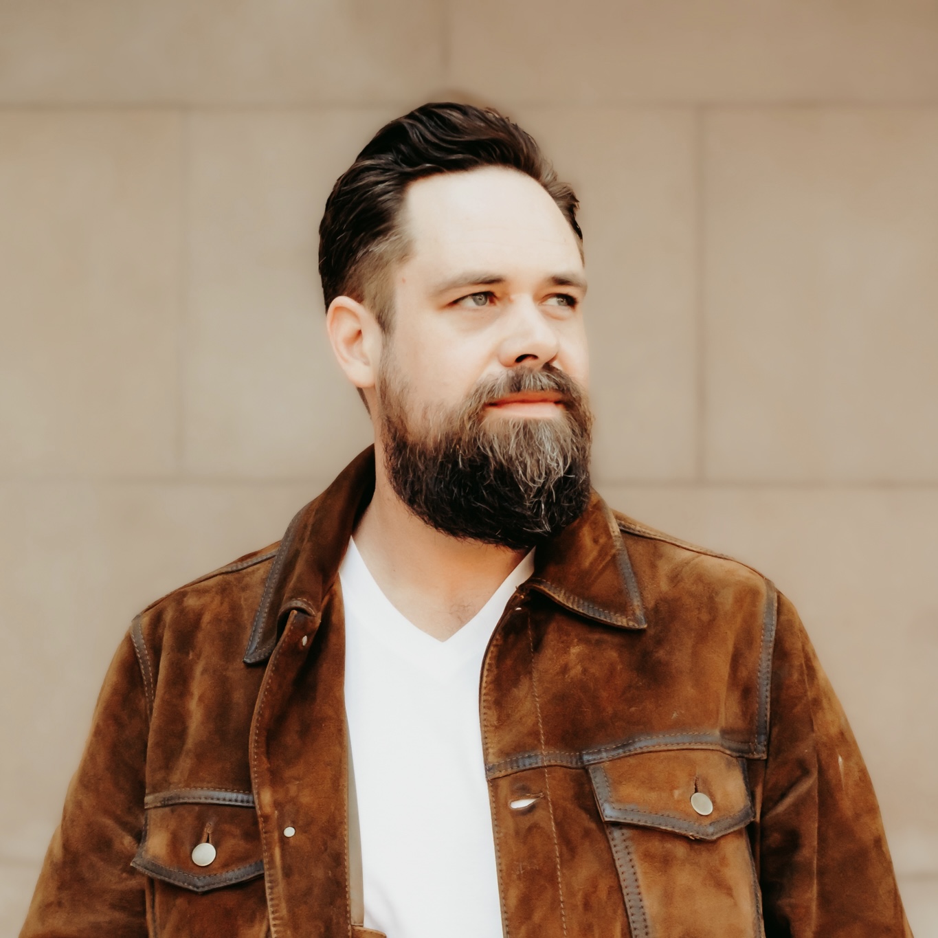 Portrait of Logan Pringle in a brown suede jacket